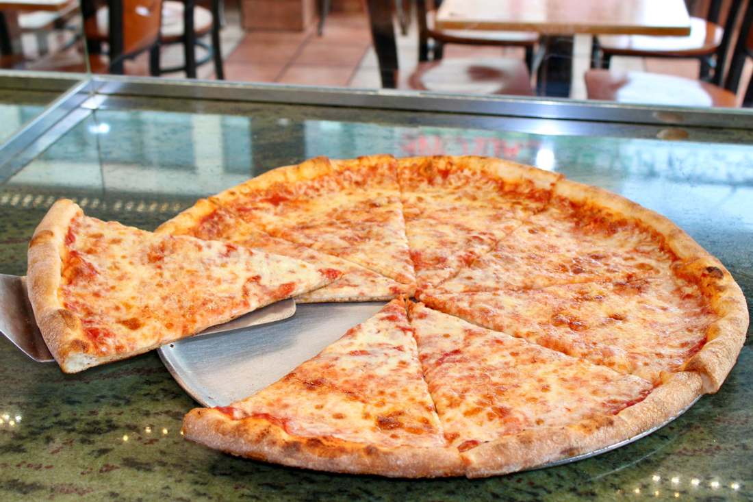 Classic cheese pizza with a slice being lifted